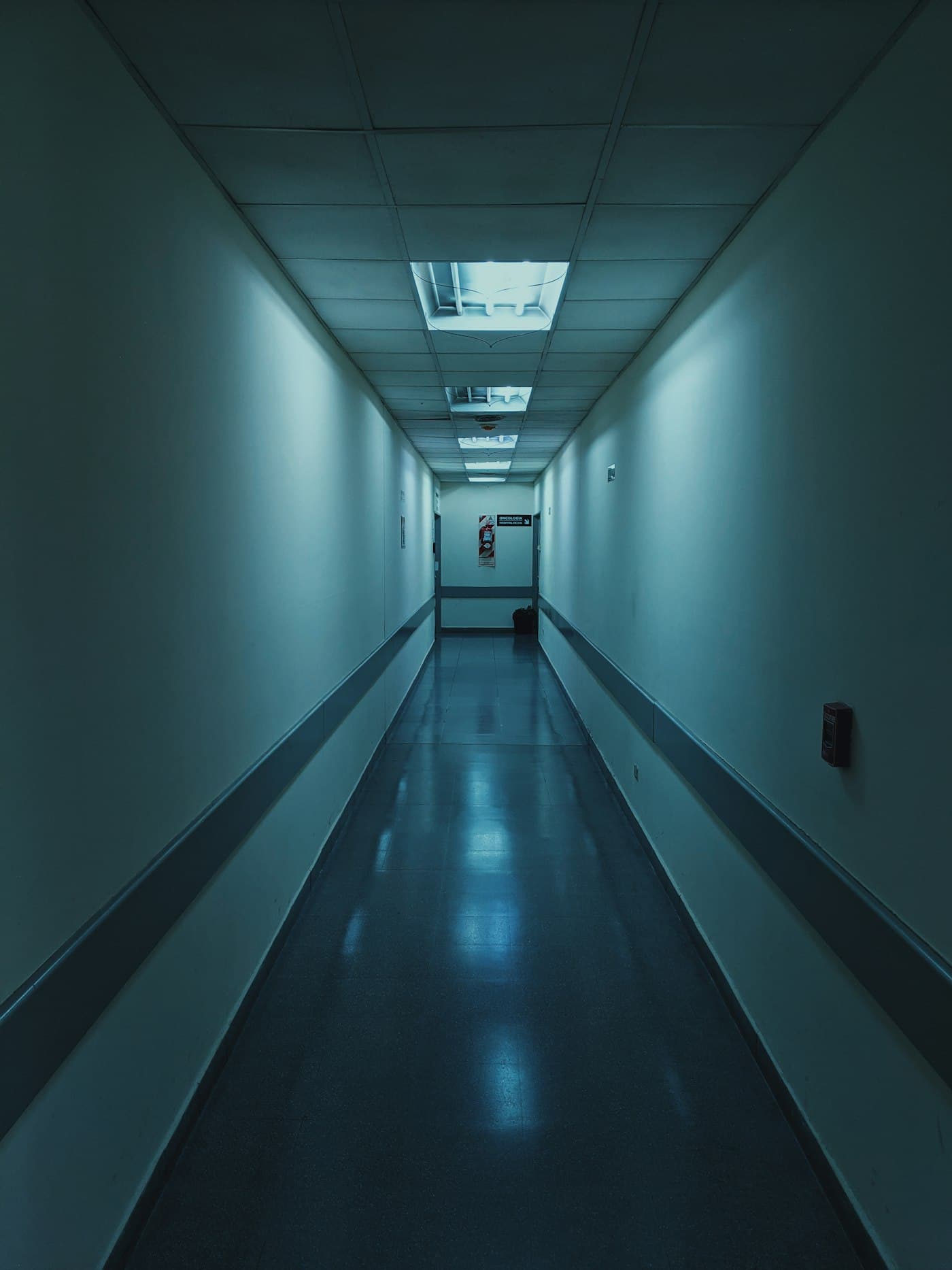 Leerer klinischer Flur mit kühlem Licht: Wachsamkeit und Spannung ohne Horror