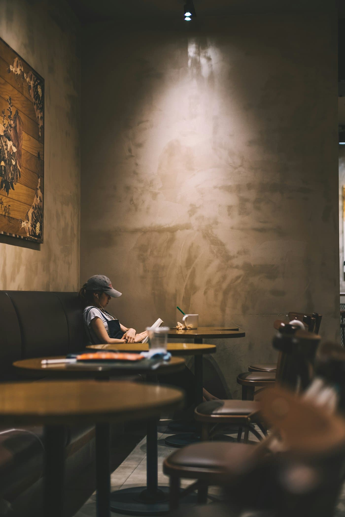 Person liest ruhig allein in einem Café: zurückhaltende Präsenz und Konzentration